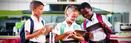 Preview: School kids using digital tablet in school cafeteria