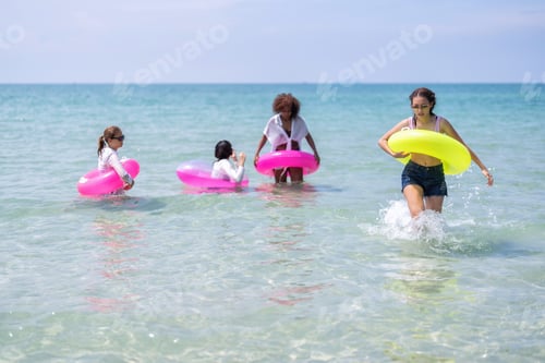 Preview: Teenage girl friendship enjoy laughing play on sea swimming with water inflation toy on blue sky day