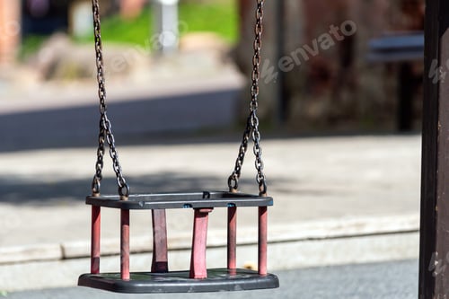 Preview: Swingset with empty seat in a sunny park during a clear afternoon