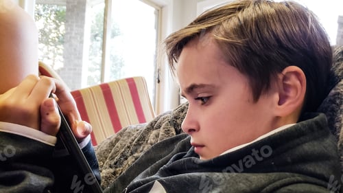 Preview: Focused Child Using a Tablet at Home Indoors