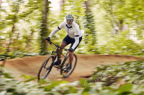 Preview: Blurred trees, cycling and man in nature training for a race, marathon or competition in forest. Fa