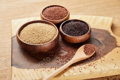 Preview: white, black and red quinoa in wooden bowls near spoon