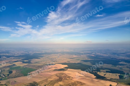 Preview: Aerial view of farm fields and distant scattered houses in rural area