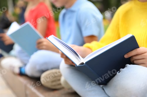 Preview: Little children reading books outdoors, closeup