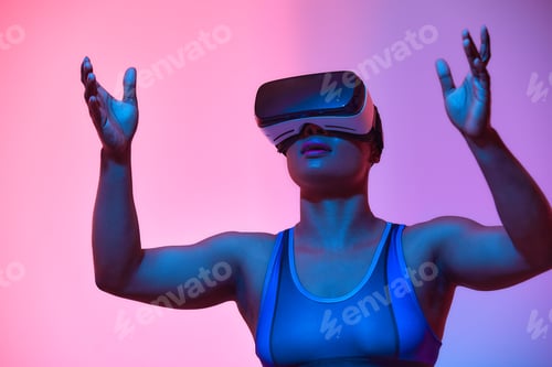 Preview: African american woman streamer playing video game using virtual reality glasses at gaming room