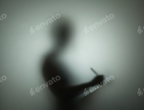 Preview: Silhouette of person using pen and clipboard, behind glass