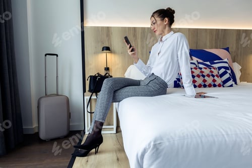 Preview: Businesswoman Using Mobile Device While Sitting in Hotel