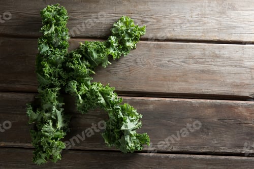 Preview: Letter K made with kale leaves on wooden table