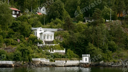 Preview: View from the lake on green bushes and trees and a building inside. Stock footage. Summer