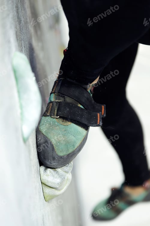 Preview: Fit woman rock climbing indoors at the gym.
