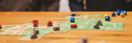 Preview: people friends have fun playing the carcassonne board game at night. game cards and chip. banner