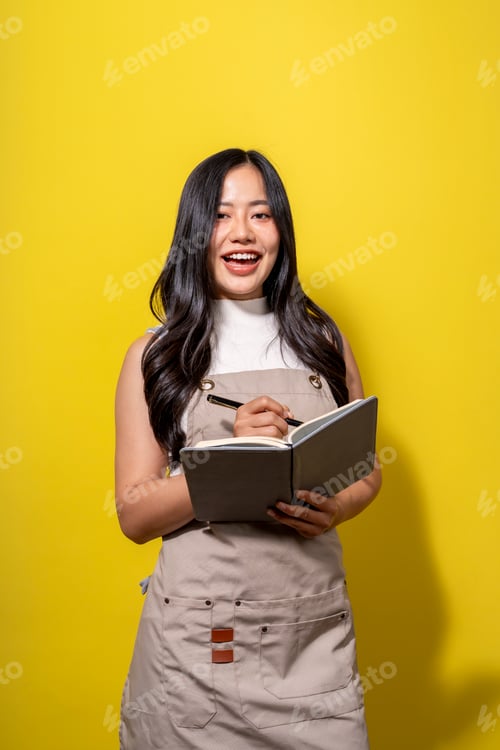 Preview: A woman is smiling and holding a book