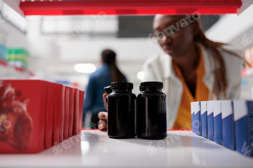 Preview: Pharmacist putting medication bottles on drugstore shelf, close up