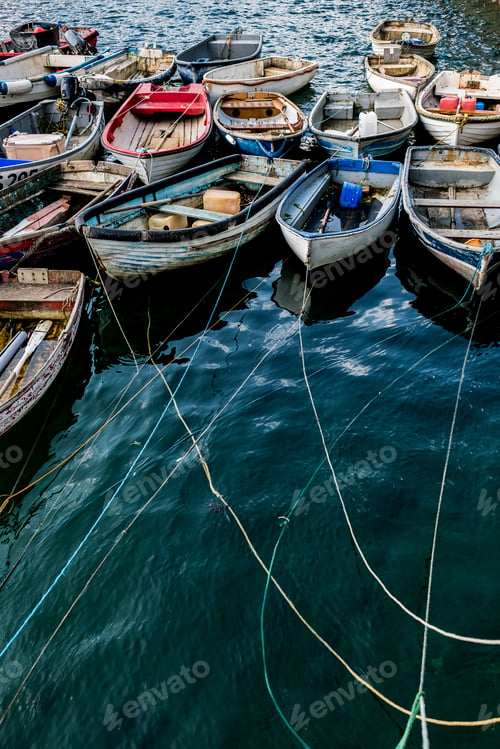 Preview: High angle view of colourful wooden fishing boats moored side by side in an harbour.