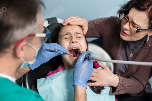 Preview: Girl with on the first dental visit. Senior pediatric dentist with mother treating patient teeth