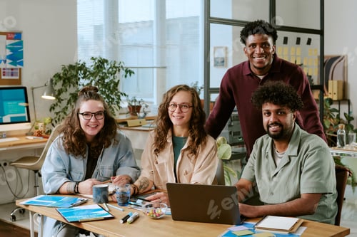 Preview: Diverse Young Adults Collaborating Around Laptop in Modern Office Workspace