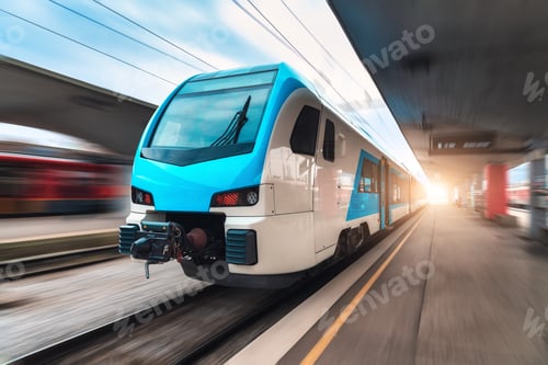 Preview: Blue high speed train in motion on the railway station at sunset