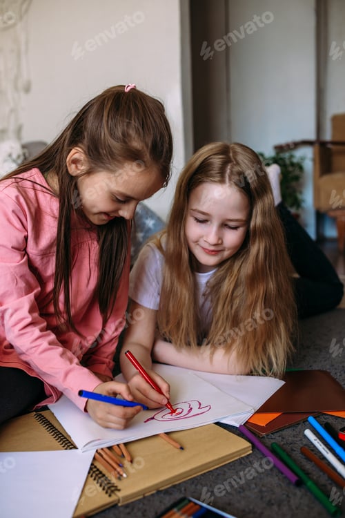 Preview: Two girls friends play at home after school, draw with pencils and felt-tip pens and have fun.