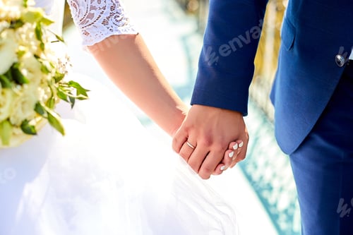Preview: Wedding bouquet holding in a hands of couple.