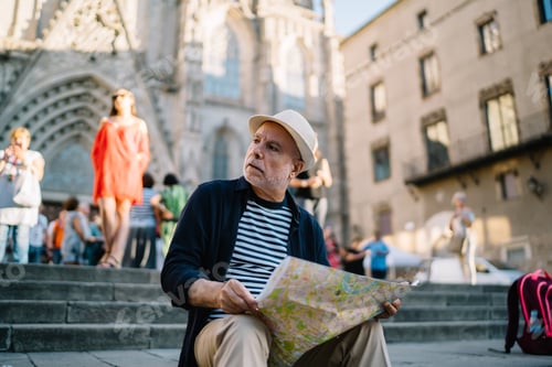 Preview: Caucasian man in straw hat holding location map resting at square in town