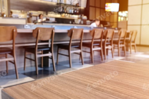 Preview: Wooden board empty table top in front of blurred cafe or restaurant background
