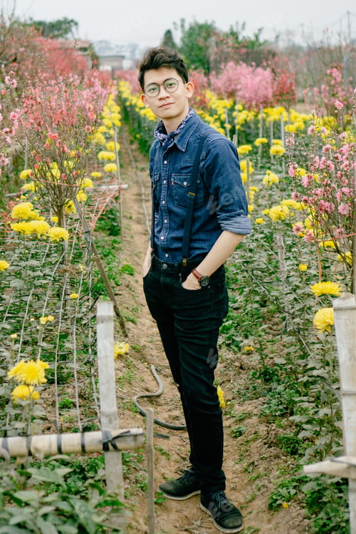 Preview: Asian guy in flower garden in Spring