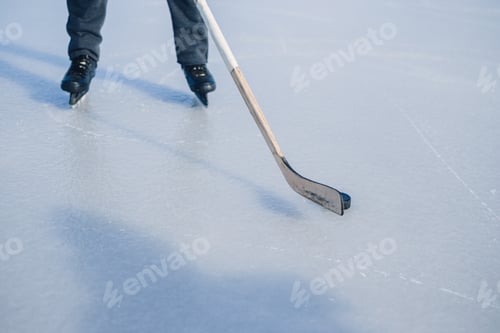 Preview: Close-up of hockey stick and puck on ice field.