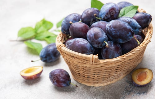 Preview: Fresh plums in wicker basket, healthy eating concept