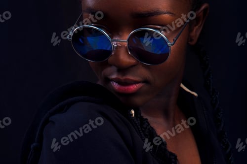 Vista previa: Close-up of woman with dark skin wearing round sunglasses