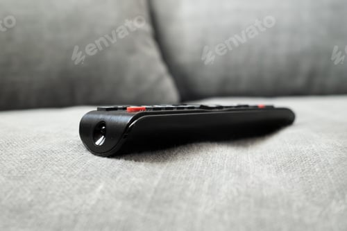 Preview: TV remote on the sofa. Concept of lazy rest and lifestyle.