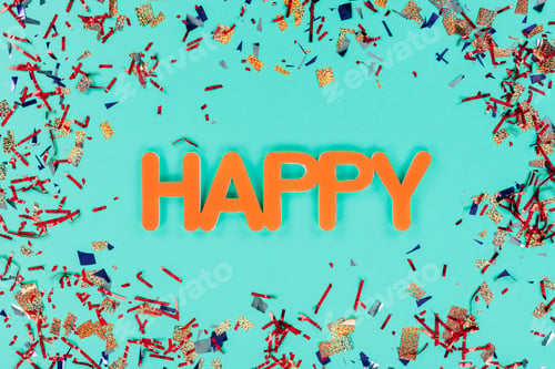 Preview: top view of happy sign surrounded with confetti on green table