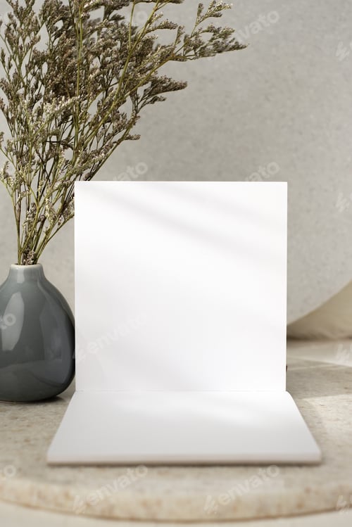 Preview: mockup open notebook with flower in vase on white stone table