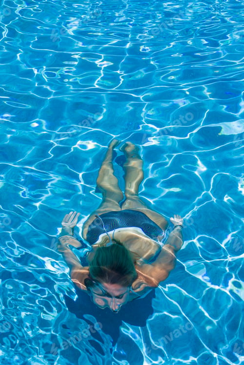 Preview: woman swimming on a blue water pool
