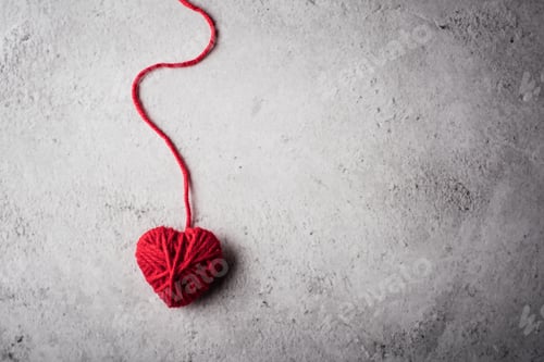 Preview: Red yarn heart shaped on the wall background
