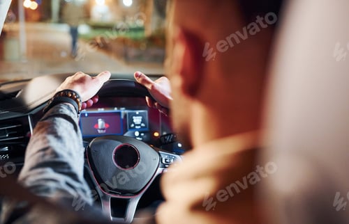 Preview: Handsome unshaved man in fashionable clothes riding his automobile