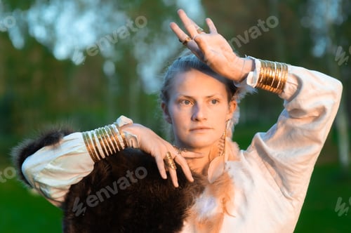 Preview: Young strong woman with fur, feather ornaments, gilded copper rings and bracelets
