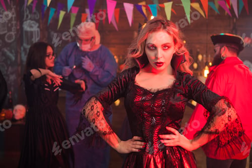 Preview: Attractive young woman posing to the camera in witch costume at halloween celebration