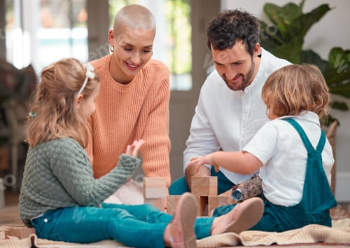 Preview: Shot of a young family having fun while playing together on the lounge floor at home