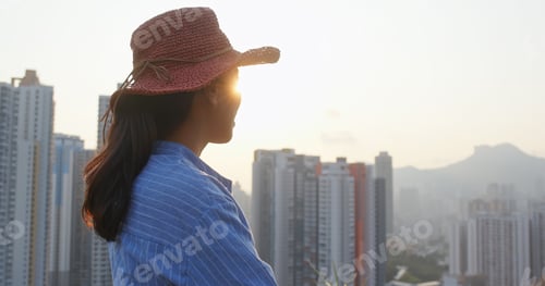 Preview: Woman wearing red straw hat and look around in the city