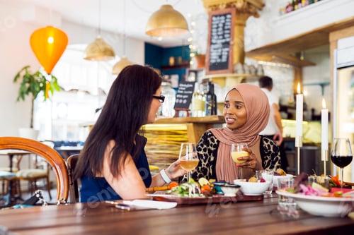 Preview: Two women enjoying a meal and conversation at a cozy restaurant.