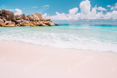 Preview: Grand Anse beach at La Digue island in Seychelles. Sandy beach with blue ocean bay, white clouds in
