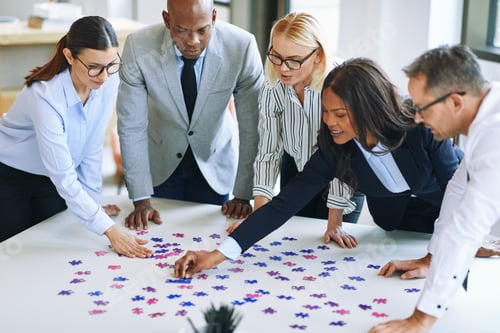 Preview: Diverse group of businesspeople working together to solve a puzzle