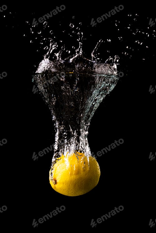 Preview: Fresh yellow lemon in water splash on black background with lots of air bubbles