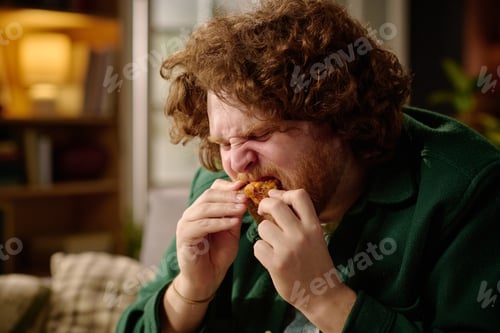 Preview: Man Enjoying Eating Crispy Fried Chicken Indoors