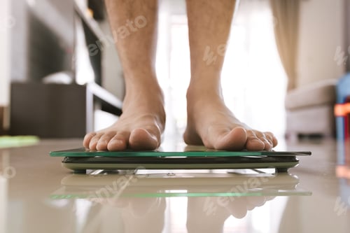 Preview: Close up of people feet standing on scale weighing.