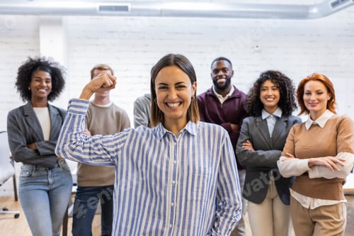 Preview: Confident businesswoman showing strength with diverse team in coworking space