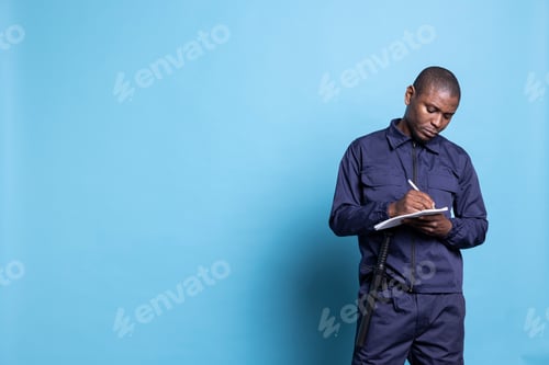 Preview: African american security guard writing information on his notebook