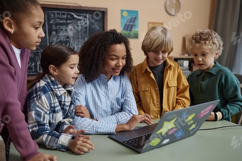 Preview: Teacher Using Computer at Desk with Diverse Group of Children