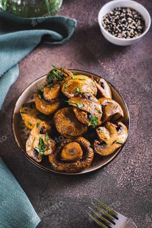 Preview: Homemade grilled mushrooms with herb on a plate on the table vertical view