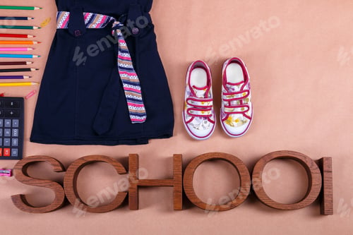 Preview: School uniform near sneakers and supplies on orange